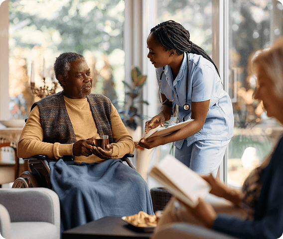 Nurse showing elderly person in a chair their medical chart