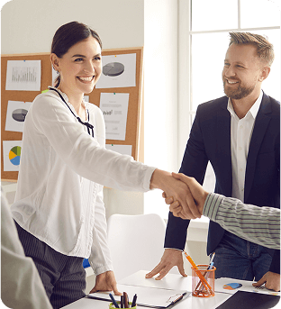 Three professionals in a room where a woman is shaking hands with a man across a desk