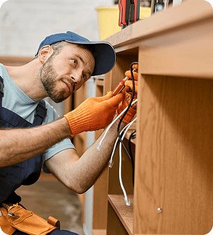 Handyman working on some wires under a cabinet